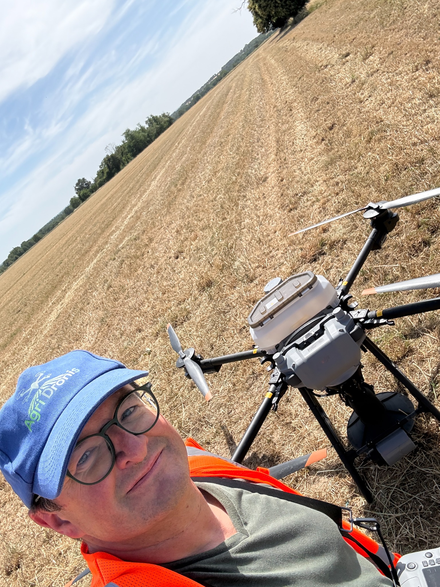 Denis Breton, télépilote Agri Dronis, avec un drone agricole sur une parcelle